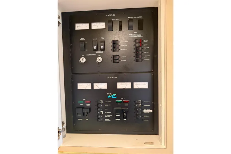 Slide: The Image of Electrical control panel of 1999 Sea Ray 400 Sundancer boat, featuring 12V DC and 120V AC systems. - 32