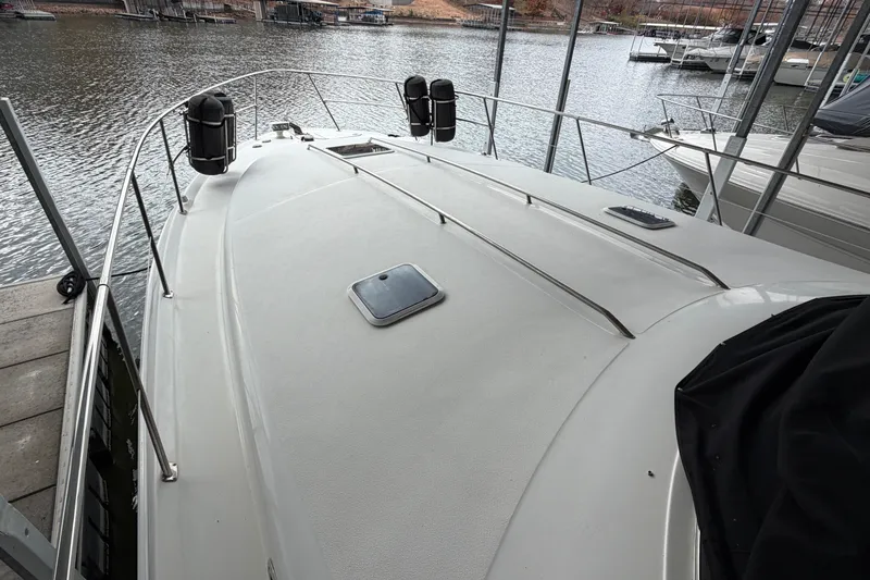 Slide: The Image of 1999 Sea Ray 400 Sundancer yacht docked, showcasing spacious deck and sleek design. - 4