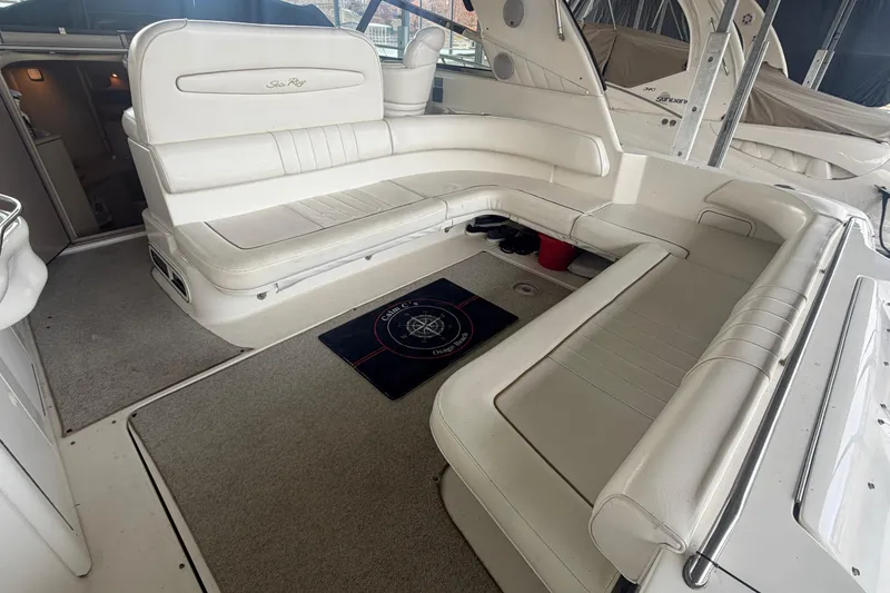 Slide: The Image of 1999 Sea Ray 400 Sundancer interior with white seating and nautical-themed mat. - 7