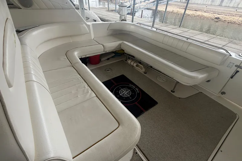 Slide: The Image of 1999 Sea Ray 400 Sundancer boat interior with white seating and carpeted floor. - 8