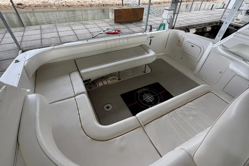 Slide: The Image of 1999 Sea Ray 400 Sundancer boat interior with white seating and carpeted floor. - 9