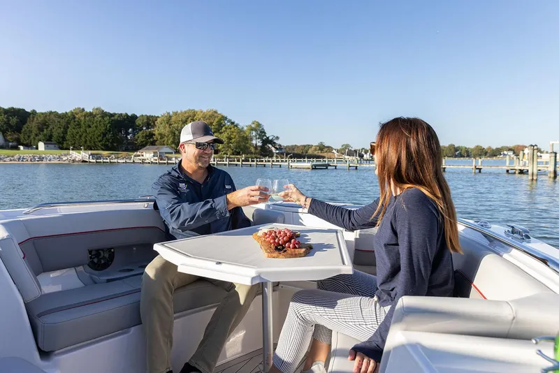 Slide: The Image of Manufacturer Provided Image: Couple enjoying a toast on a 2025 Solara S-250 CW boat, with a scenic waterfront view. - 13