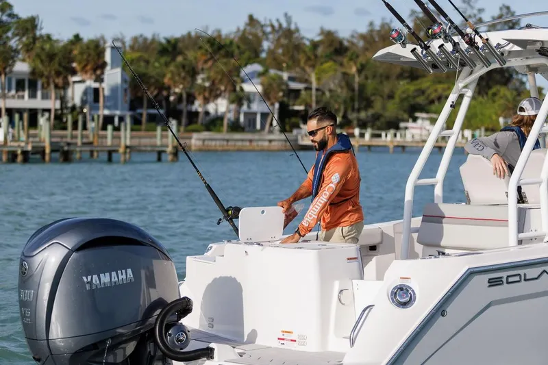 Slide: The Image of Manufacturer Provided Image: Man fishing on Solara S-250 CW boat, 2025 model, with Yamaha engine in scenic waters. - 2