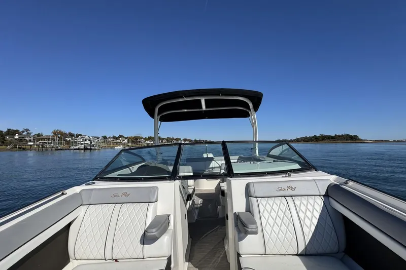 Slide: The Image of 2017 Sea Ray SDX 270 Outboard interior with blue LED lighting and cushioned seating. - 15