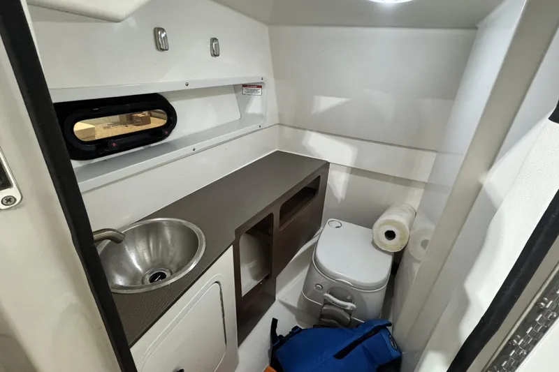 Slide: The Image of 2017 Sea Ray SDX 270 Outboard cabin with sink, toilet, and storage space. - 20