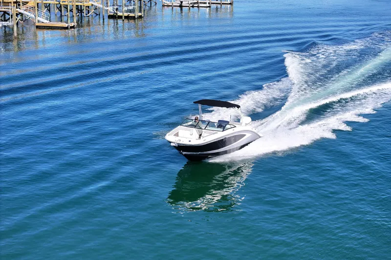 Slide: The Image of 2017 Sea Ray SDX 270 Outboard cruising on clear blue water near a dock. - 9