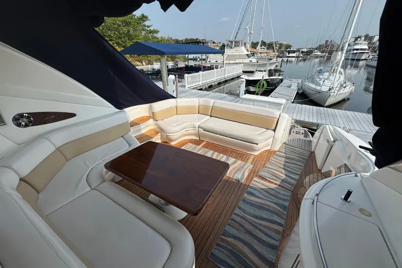 Slide: The Image of Luxurious 2001 Sea Ray 540 Sundancer yacht interior with elegant seating and wooden table at marina. - 12