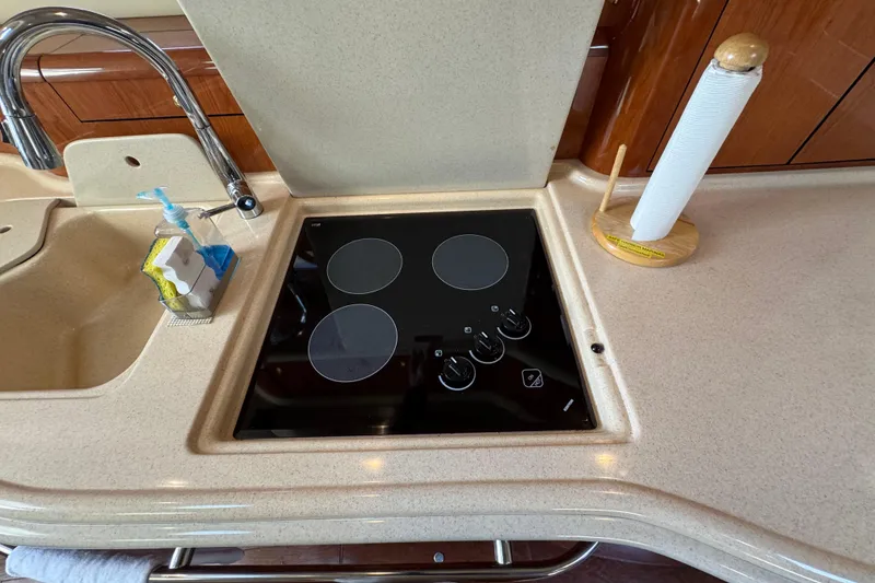 Slide: The Image of 2001 Sea Ray 540 Sundancer kitchen with stovetop, sink, and paper towel holder. - 22