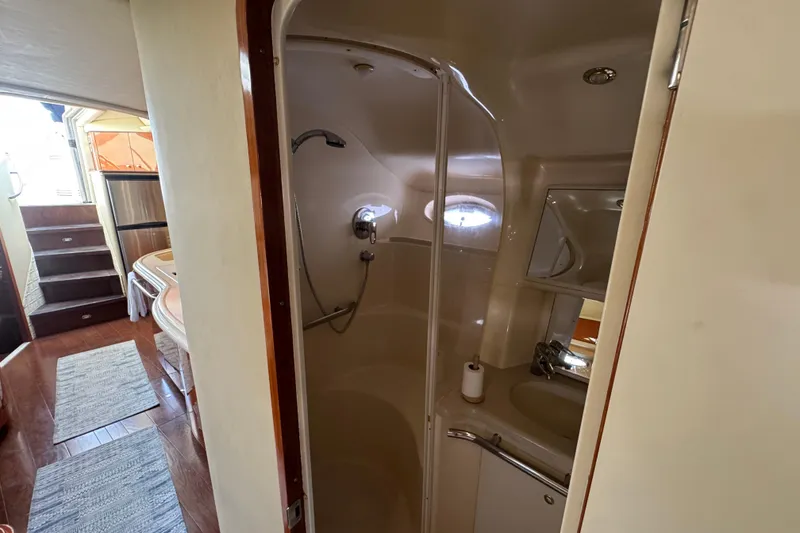 Slide: The Image of Interior of 2001 Sea Ray 540 Sundancer yacht, featuring a compact bathroom and wooden flooring. - 27