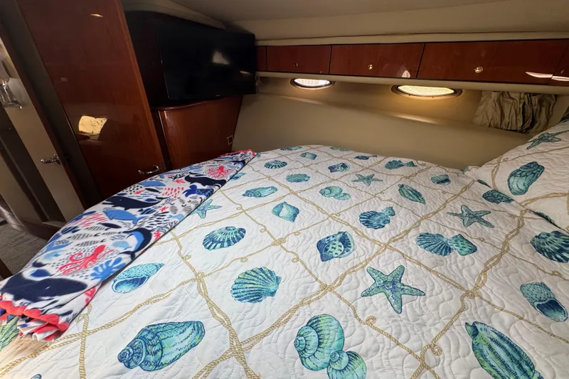 Slide: The Image of Cozy cabin interior of 2001 Sea Ray 540 Sundancer with nautical-themed bedding. - 30