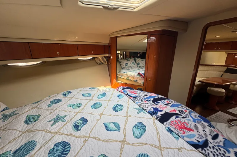 Slide: The Image of Luxurious 2001 Sea Ray 540 Sundancer cabin with nautical-themed bedding and elegant wood finishes. - 31
