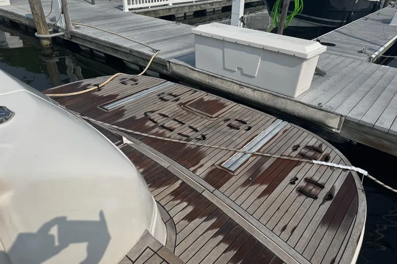 Slide: The Image of 2001 Sea Ray 540 Sundancer yacht docked, featuring a wooden deck and marina setting. - 5