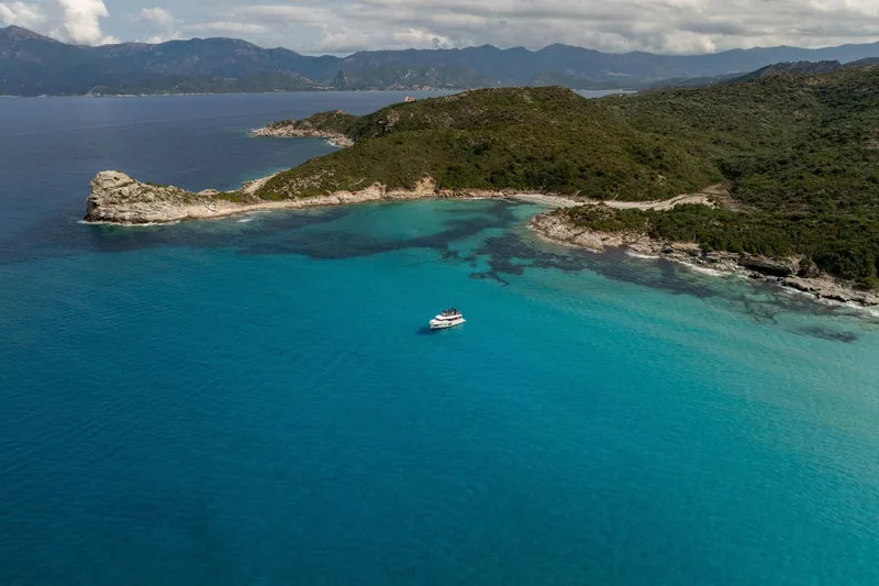 Slide: The Image of Aerial view of 2025 Beneteau Grand Trawler 63 in turquoise coastal waters. - 39