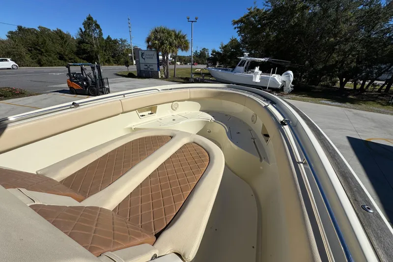 Slide: The Image of 2019 Chris-Craft Catalina 30 boat interior with tan cushioned seating, parked outdoors. - 17