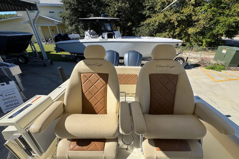 Slide: The Image of 2019 Chris-Craft Catalina 30 boat seats with diamond-pattern upholstery in a marina setting. - 27