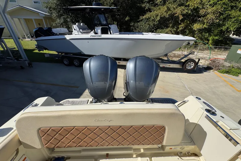 Slide: The Image of 2019 Chris-Craft Catalina 30 with dual engines, parked near a Fountain boat on a trailer. - 36