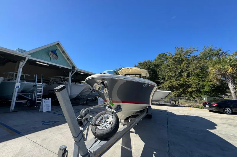 Slide: The Image of 2019 Chris-Craft Catalina 30 boat on trailer, parked outside dealership under clear blue sky. - 5