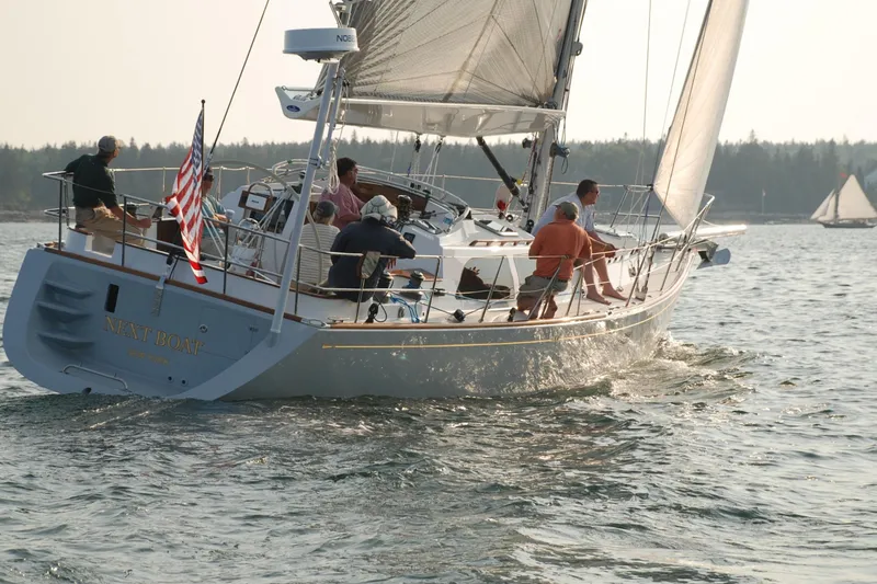 Slide: The Image of Sailing on a 2007 Morris Ocean Series 45 yacht with crew, American flag, and scenic backdrop. - 3
