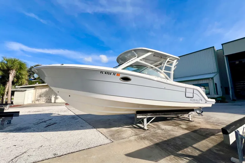 The Image of 2021 Robalo R317 Dual Console boat on trailer, sunny day, blue sky background. - 0