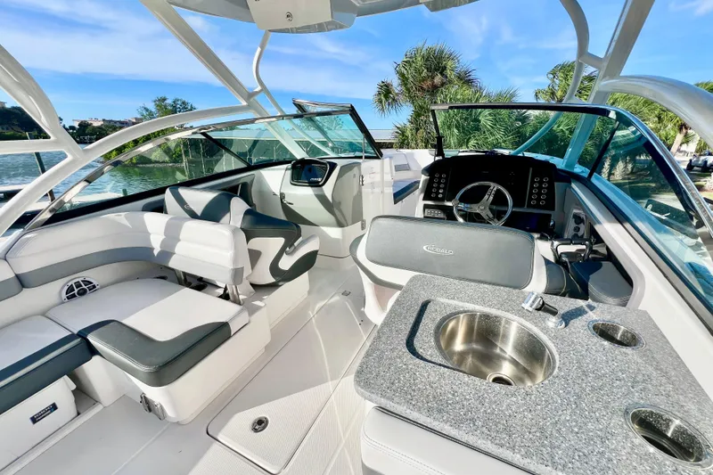 Slide: The Image of 2021 Robalo R317 Dual Console boat interior with seating and helm, docked by the water. - 15