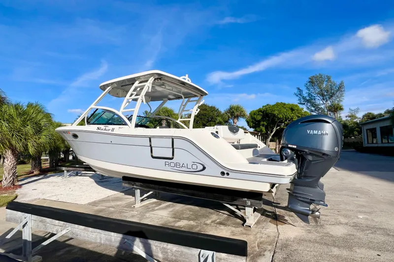 Slide: The Image of 2021 Robalo R317 Dual Console boat on display under clear blue sky. - 2