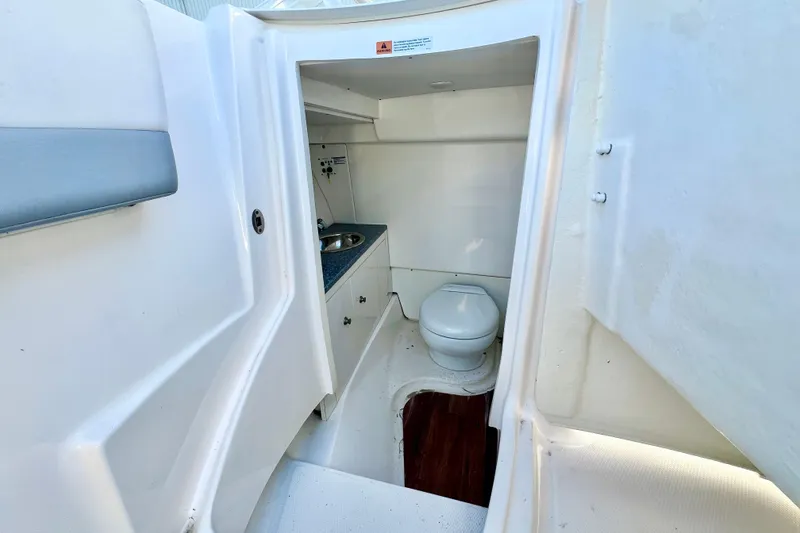 Slide: The Image of 2021 Robalo R317 Dual Console boat interior with compact bathroom and sink. - 25