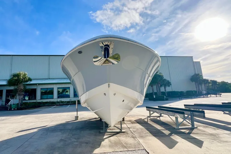 Slide: The Image of 2021 Robalo R317 Dual Console boat on display by the water under a sunny sky. - 7