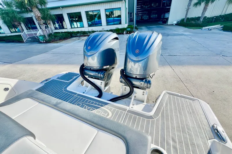 Slide: The Image of 2021 Robalo R317 Dual Console boat displayed outdoors under a bright sky. - 8