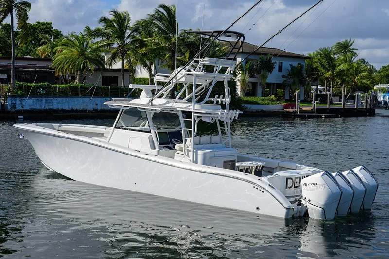 Slide: The Image of 2021 Yellowfin 42 boat with multiple engines docked near palm trees. - 13