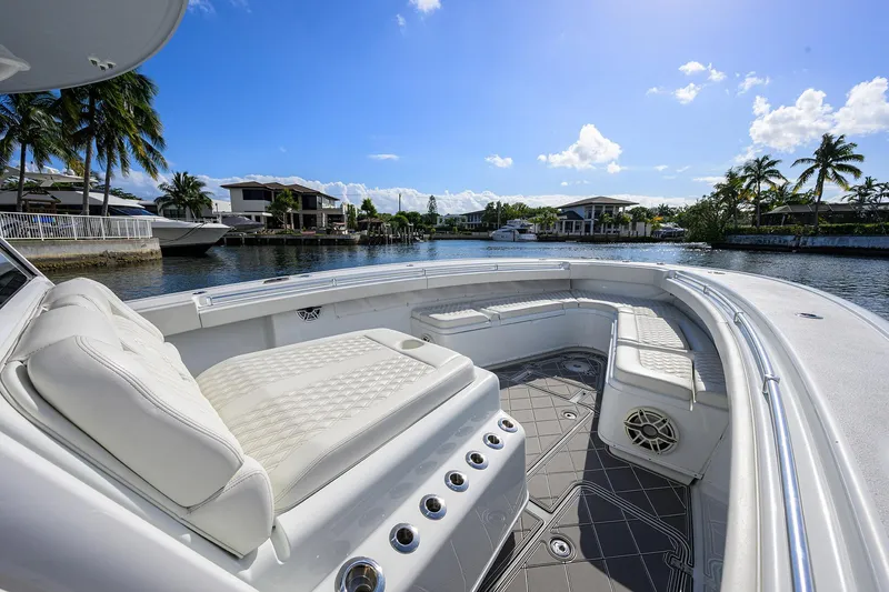 Slide: The Image of 2021 Yellowfin 42 boat with luxurious seating, docked in a scenic waterfront location. - 16