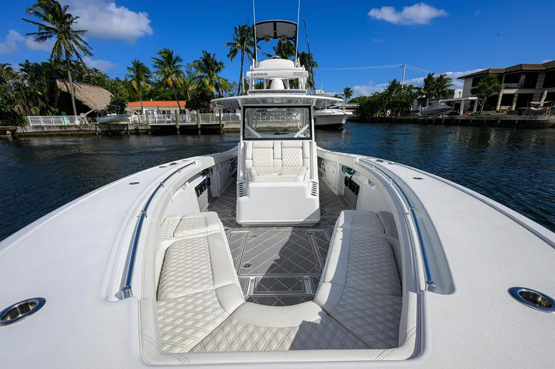 Slide: The Image of 2021 Yellowfin 42 boat with luxurious seating, docked in a scenic waterfront location. - 21