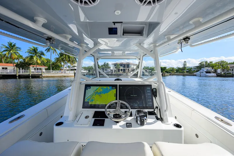 Slide: The Image of 2021 Yellowfin 42 boat cockpit with advanced navigation system, steering wheel, and waterfront view. - 30