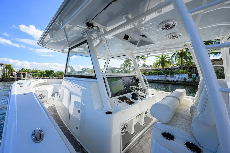 Slide: The Image of 2021 Yellowfin 42 boat interior with modern helm, white seating, and tropical waterfront view. - 32