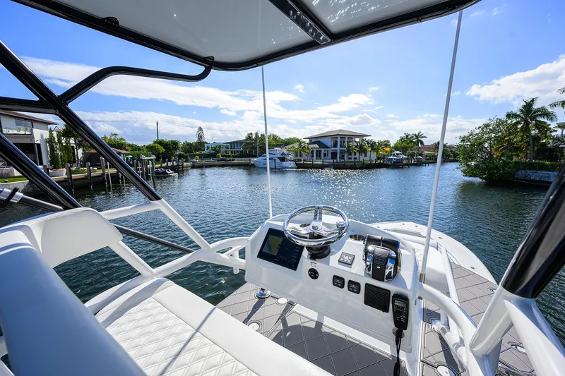Slide: The Image of 2021 Yellowfin 42 boat helm with waterfront view, clear skies, and modern controls. - 35