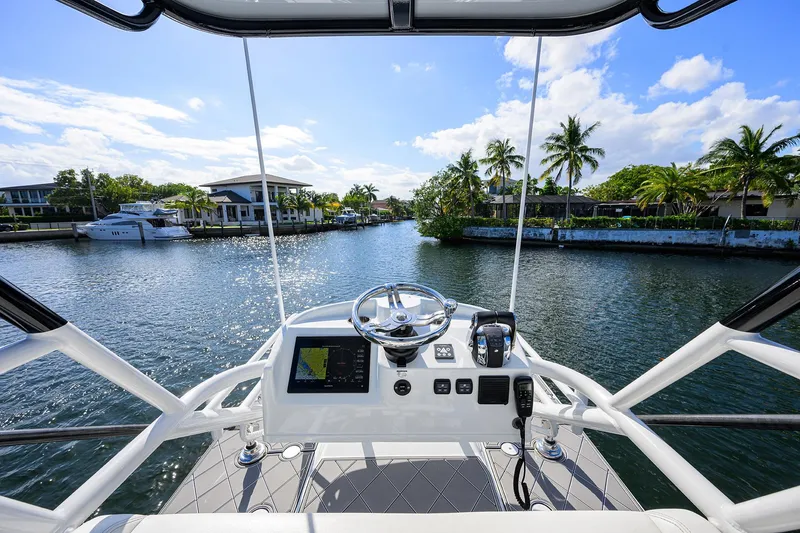 Slide: The Image of Cockpit view of 2021 Yellowfin 42 boat navigating a scenic waterway with palm trees. - 36
