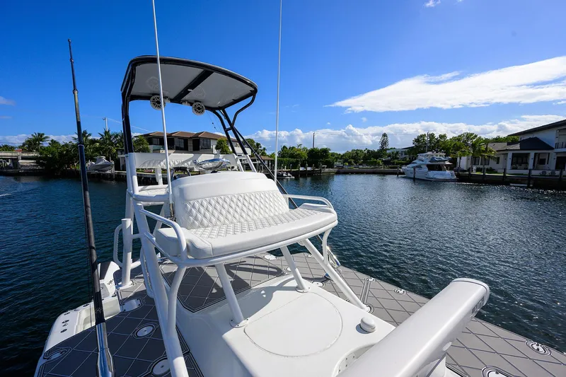 Slide: The Image of 2021 Yellowfin 42 boat with elevated seating, docked in a serene marina under a clear blue sky. - 40