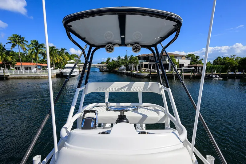 Slide: The Image of 2021 Yellowfin 42 boat navigating a scenic canal with palm trees and waterfront homes. - 41