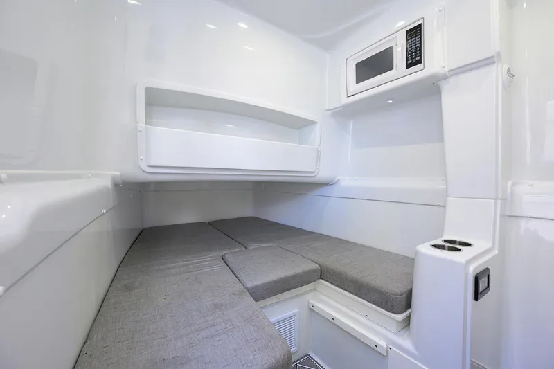 Slide: The Image of 2021 Yellowfin 42 interior cabin with gray cushions and built-in microwave. - 45