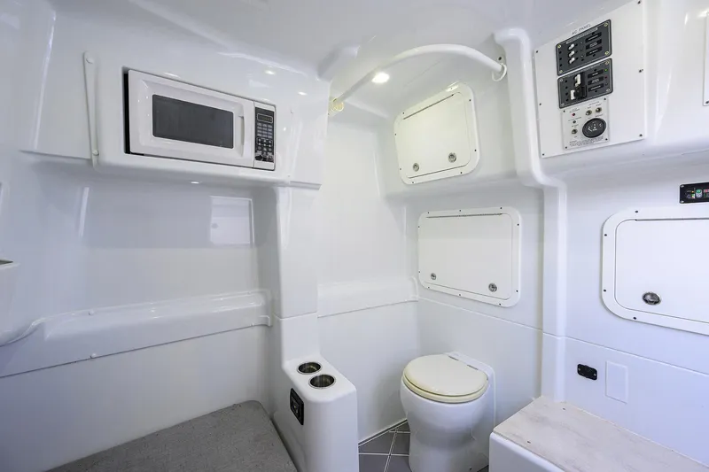 Slide: The Image of 2021 Yellowfin 42 interior with microwave, toilet, and control panels in a sleek white design. - 47