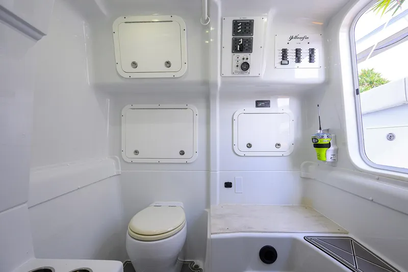 Slide: The Image of Interior of 2021 Yellowfin 42 boat featuring a compact bathroom with toilet and storage. - 48