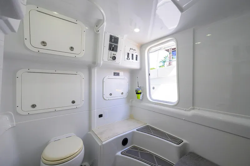 Slide: The Image of 2021 Yellowfin 42 boat interior with white cabin, storage compartments, and a window. - 49