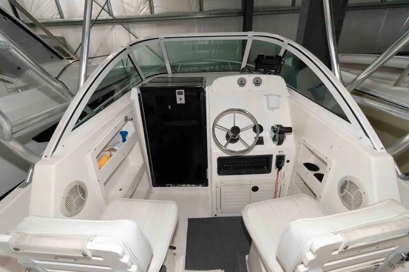 Slide: The Image of 1999 Mako 253 Walk Around boat interior with steering wheel and seating. - 5