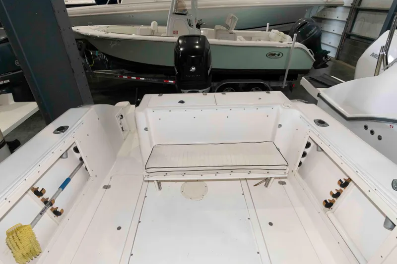 Slide: The Image of 1999 Mako 253 Walk Around boat interior with seating and storage compartments. - 7