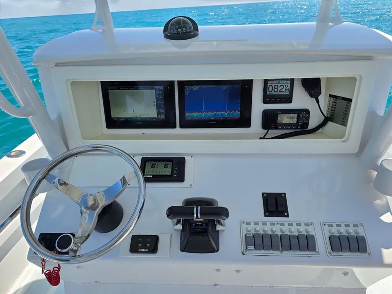 Slide: The Image of 2012 Contender Custom 33 Center Console dashboard with steering wheel and navigation displays. - 13