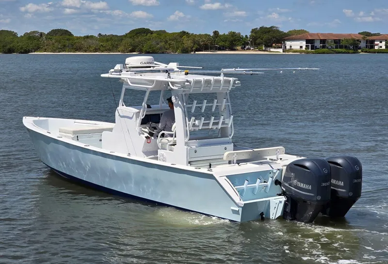 Slide: The Image of 2012 Contender Custom 33 Center Console boat on calm water, featuring dual Yamaha engines. - 29