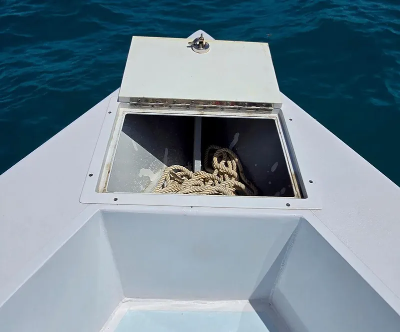 Slide: The Image of 2012 Contender Custom 33 Center Console with open storage compartment and rope, on blue water. - 7