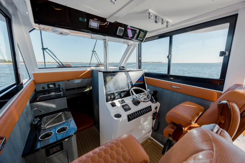 Slide: The Image of 2024 Invincible 46 Pilothouse interior with modern helm and luxurious seating. - 10