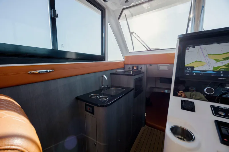 Slide: The Image of 2024 Invincible 46 Pilothouse interior with navigation display and compact kitchenette. - 13