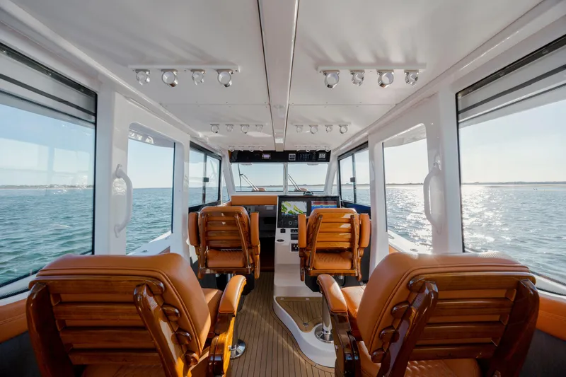 Slide: The Image of 2024 Invincible 46 Pilothouse interior with leather seats and panoramic ocean views. - 15