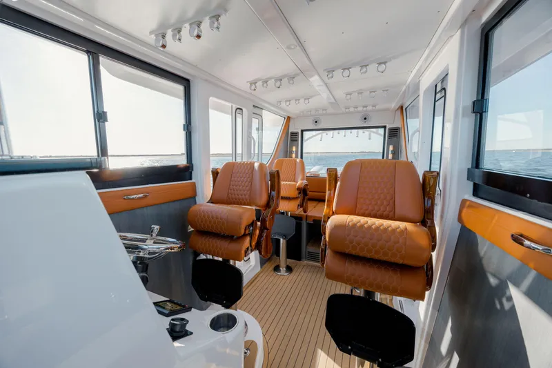Slide: The Image of 2024 Invincible 46 Pilothouse interior with luxurious seating and panoramic windows. - 16